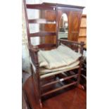 An early 20th Century mahogany and mixed wood ladder back rocking chair with slender spindles to