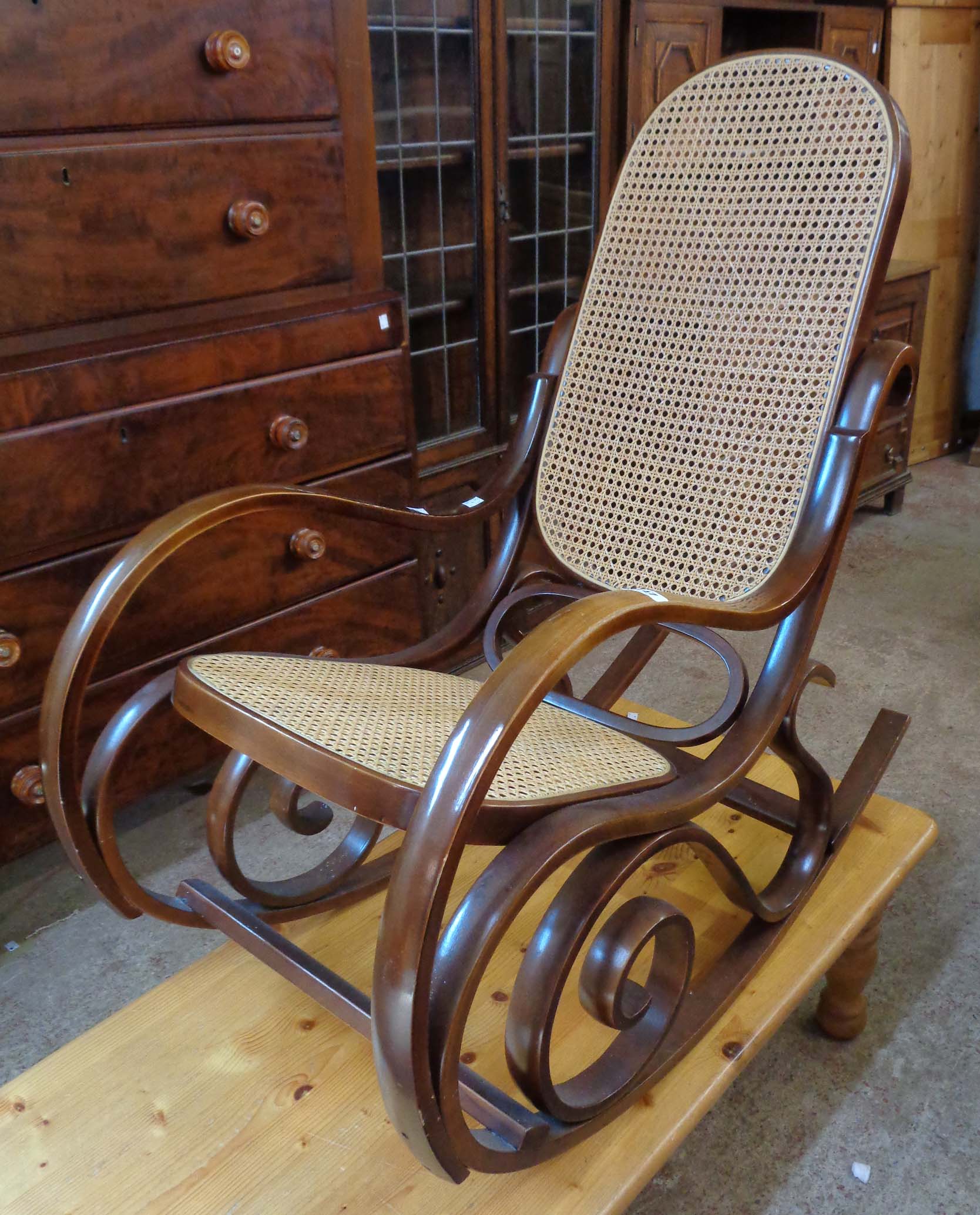 A modern Victorian style bentwood rocking chair with rattan back and seat panels