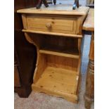 An 18" modern waxed pine bedside table with single drawer and shelf under, set on shaped standard
