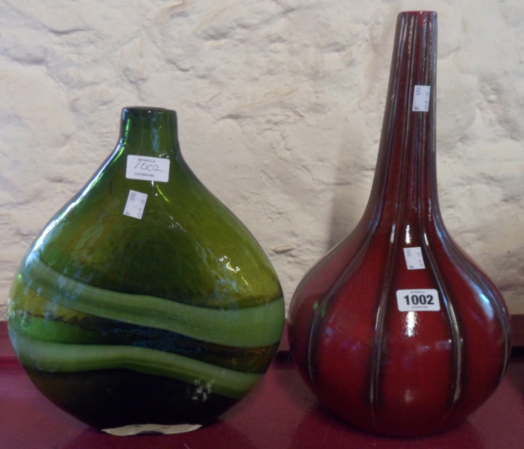 A large green flat-sided art glass bottle vase and a red ribbed art glass bottle vase