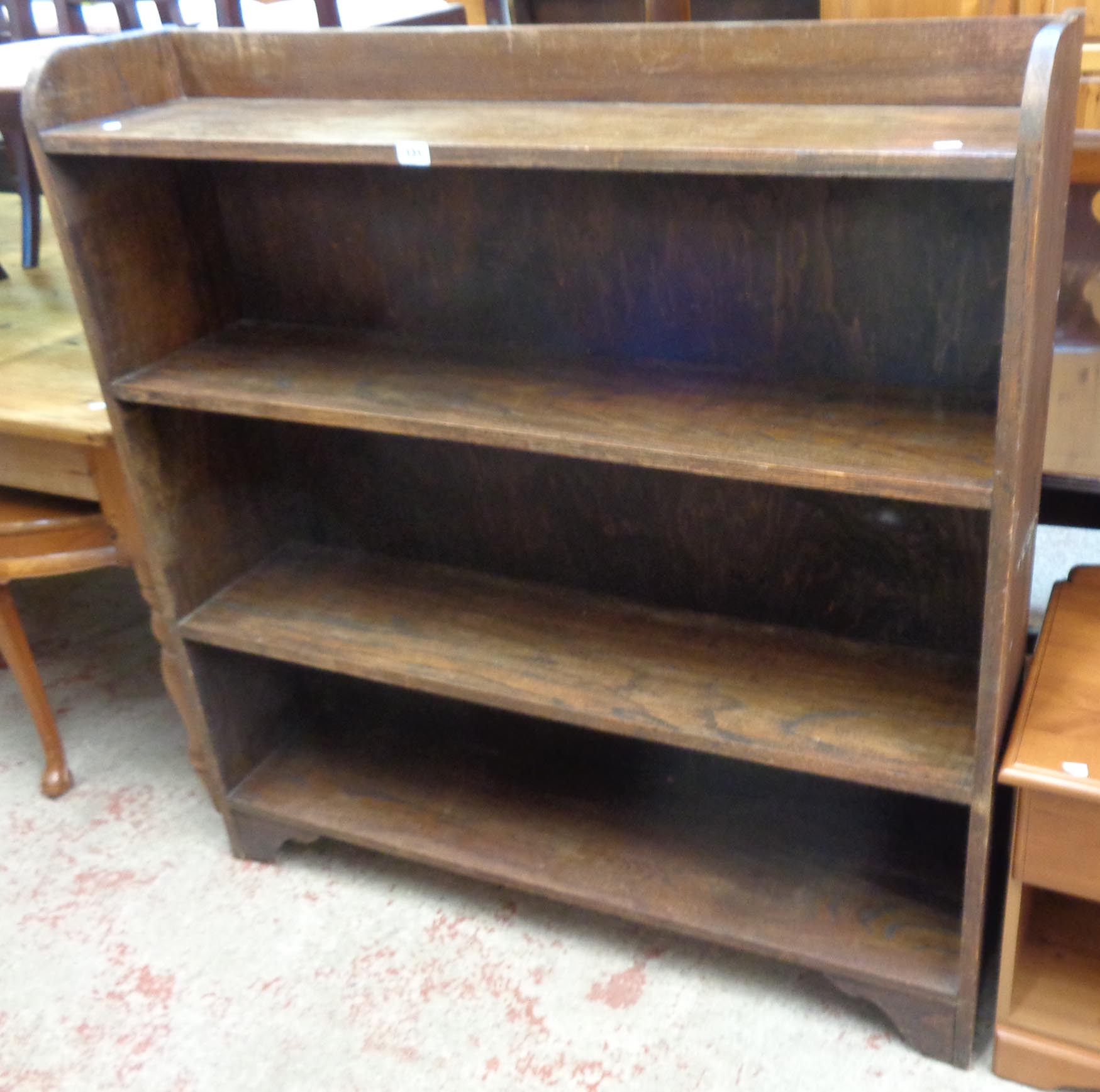 A 3' 11 1/2" stained oak four shelf open bookcase, set on bracket feet