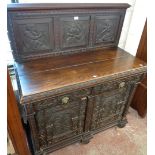 A 3' 10" Victorian carved oak sideboard with figural panels to raised back, two drawers with lion