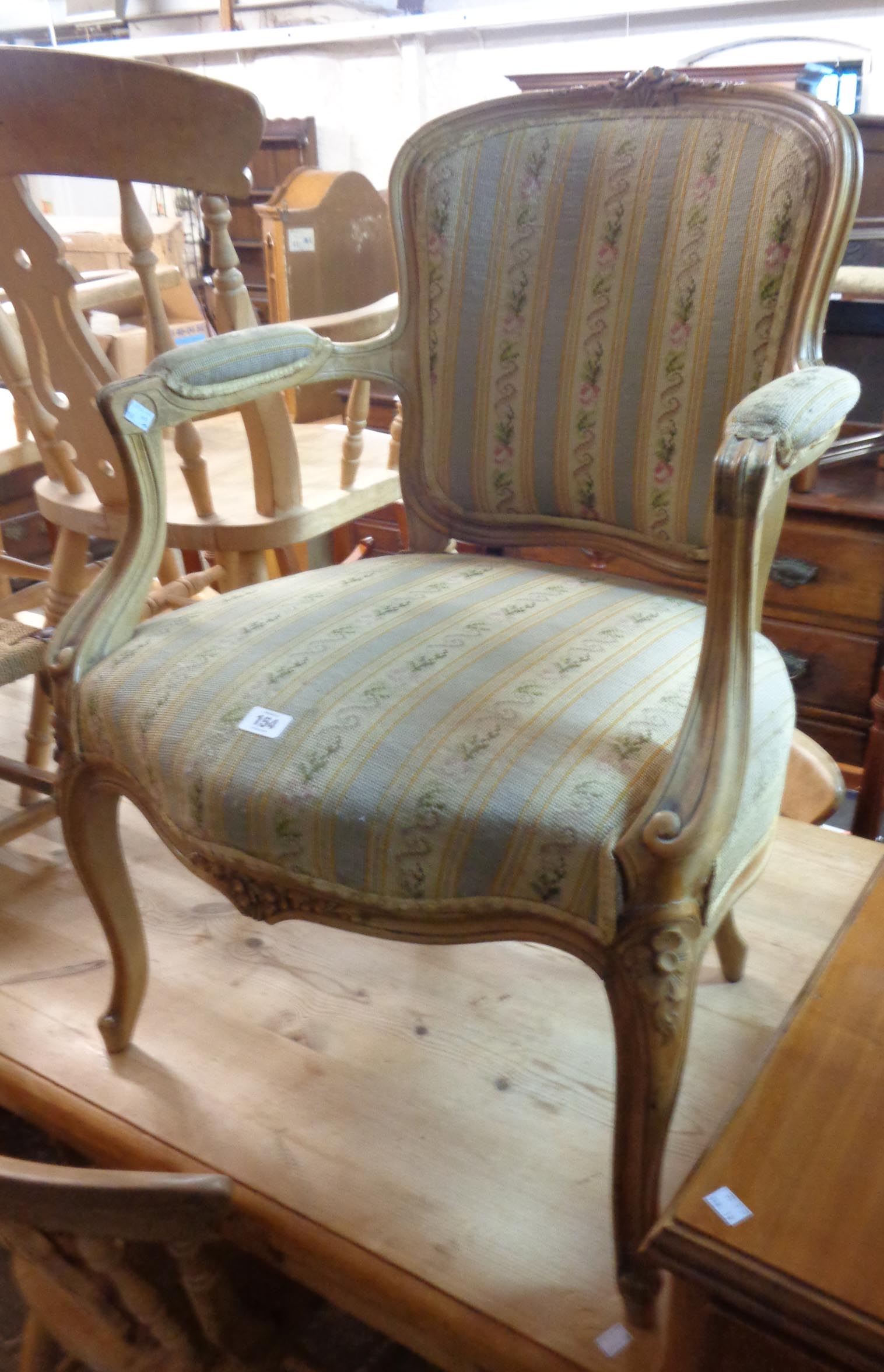 A 20th Century French style polished wood show frame salon armchair with tapestry upholstery and