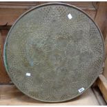 A 23 1/2" diameter embossed brass topped table set on a damaged barley twist folding base