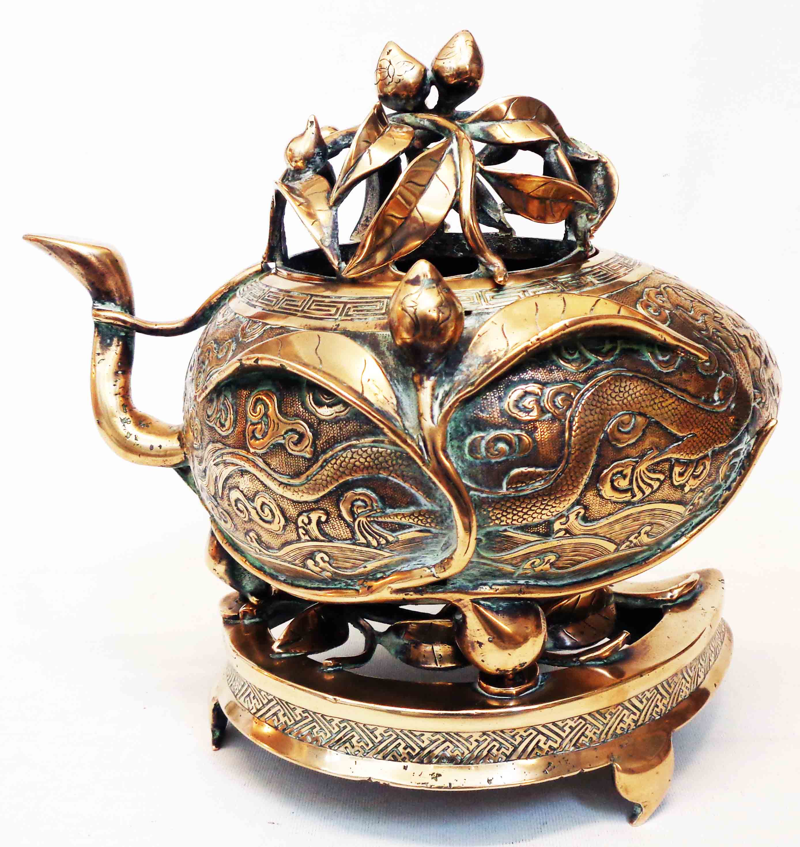 An antique Chinese bronze censer of asymmetric form with engraved air dragon and meandering