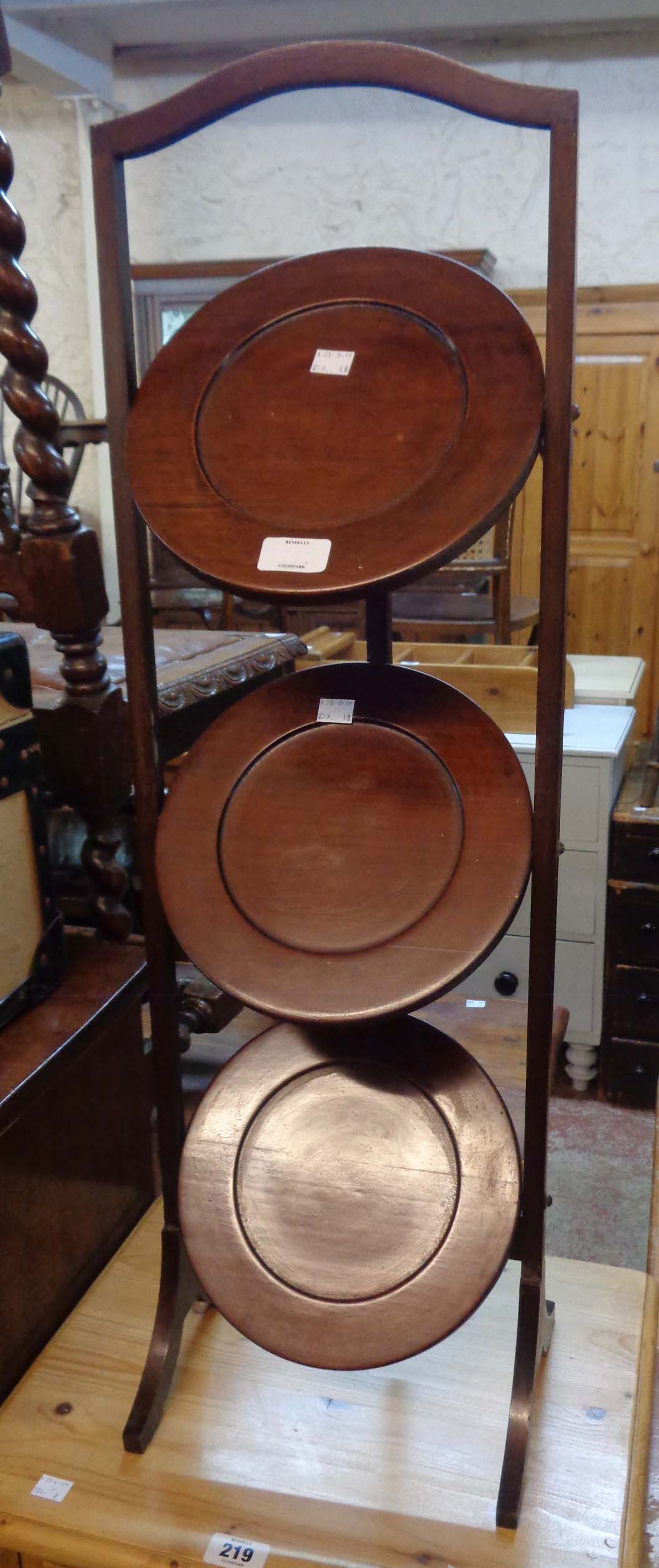 An early 20th Century mahogany three-tier folding cake stand