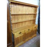 A 5' modern polished pine two part dresser with two shelf plate rack, over a base with three short