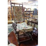 An antique American polished wood framed rocking chair with turned supports and printed upholstery