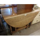 A 36" polished oak gateleg table, set on turned supports