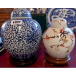 A blue and white ginger jar on stand - sold with another with prunus decoration