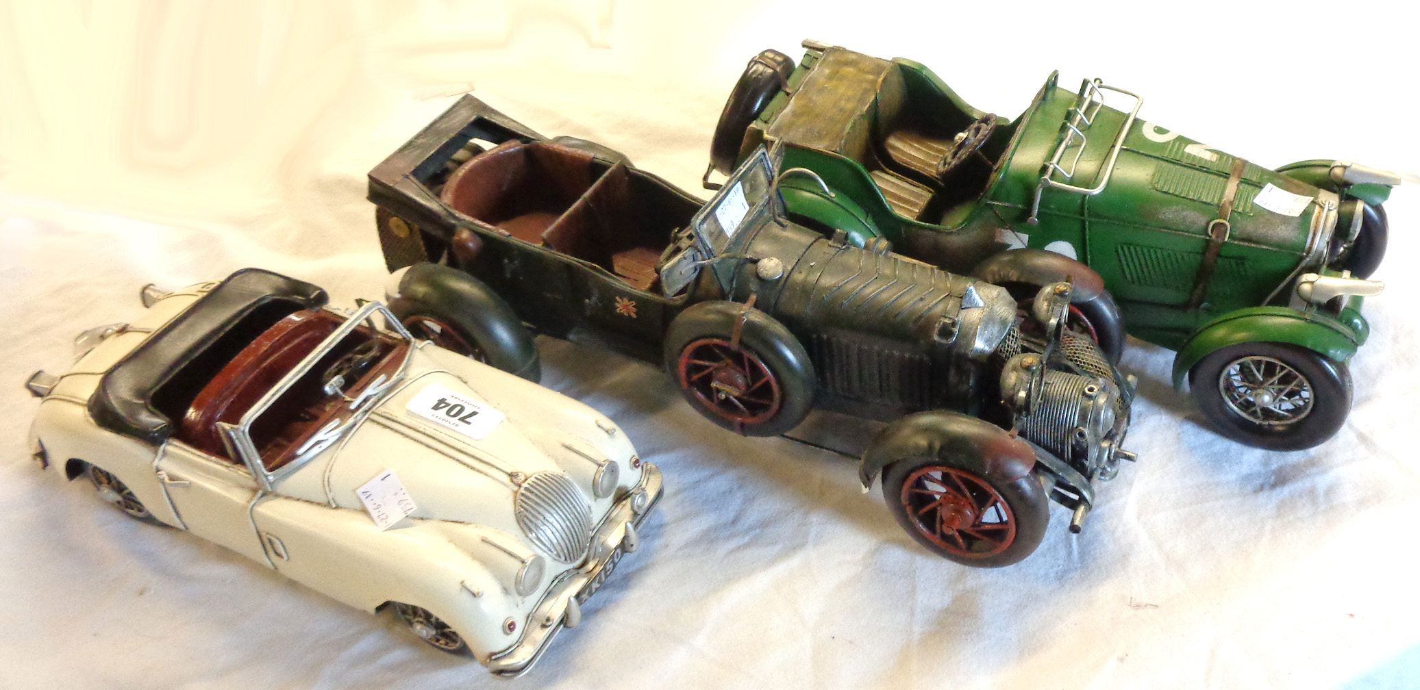 A modern tinplate model of a vintage Bentley, a similar Jaguar and another