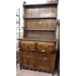 A 3' 2 1/2" 20th Century polished oak two part dresser with three shelf open plate rack over a