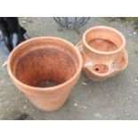 A terracotta strawberry planter and a flower pot