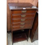 A 19 1/2" Edwardian stained walnut music chest with five Stone's Patent fall-front drawers and