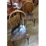 A set of four vintage Ercol hoop stick back kitchen chairs with fleur de lys decoration and solid