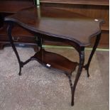 A 29" Edwardian stained walnut two-tier occasional table with shaped moulded surfaces and slender