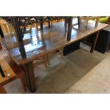 A 6' 10" antique French polished oak dining table with triple plank top, set on chamfered square