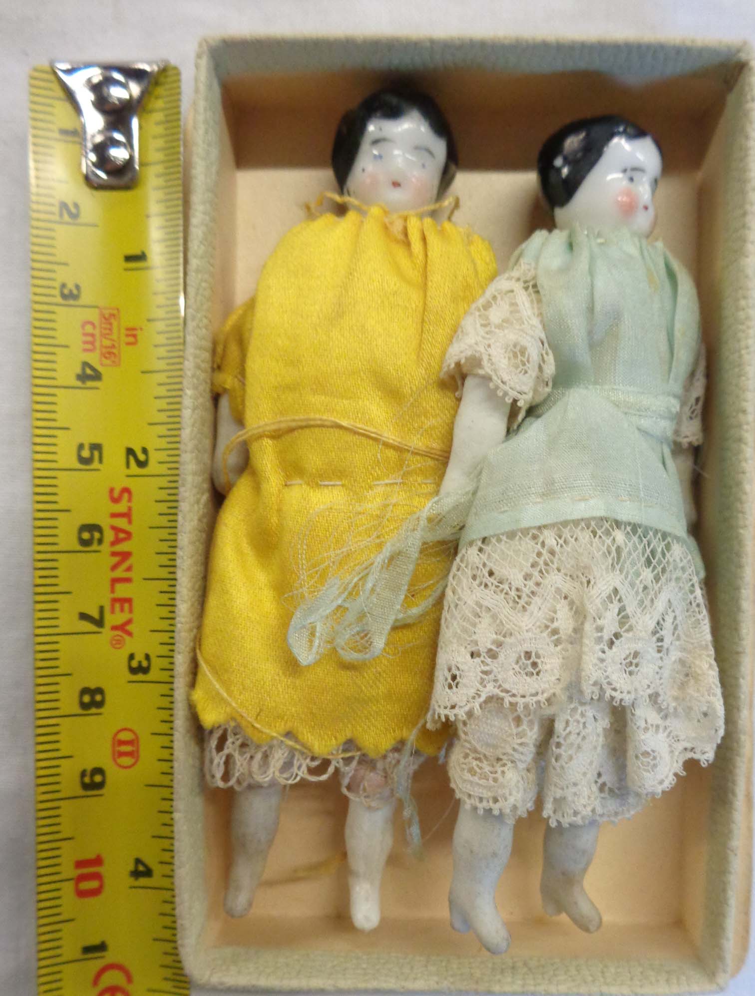 A pair of antique miniature porcelain headed dolls with indistinct marks to back of heads