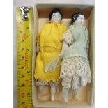 A pair of antique miniature porcelain headed dolls with indistinct marks to back of heads