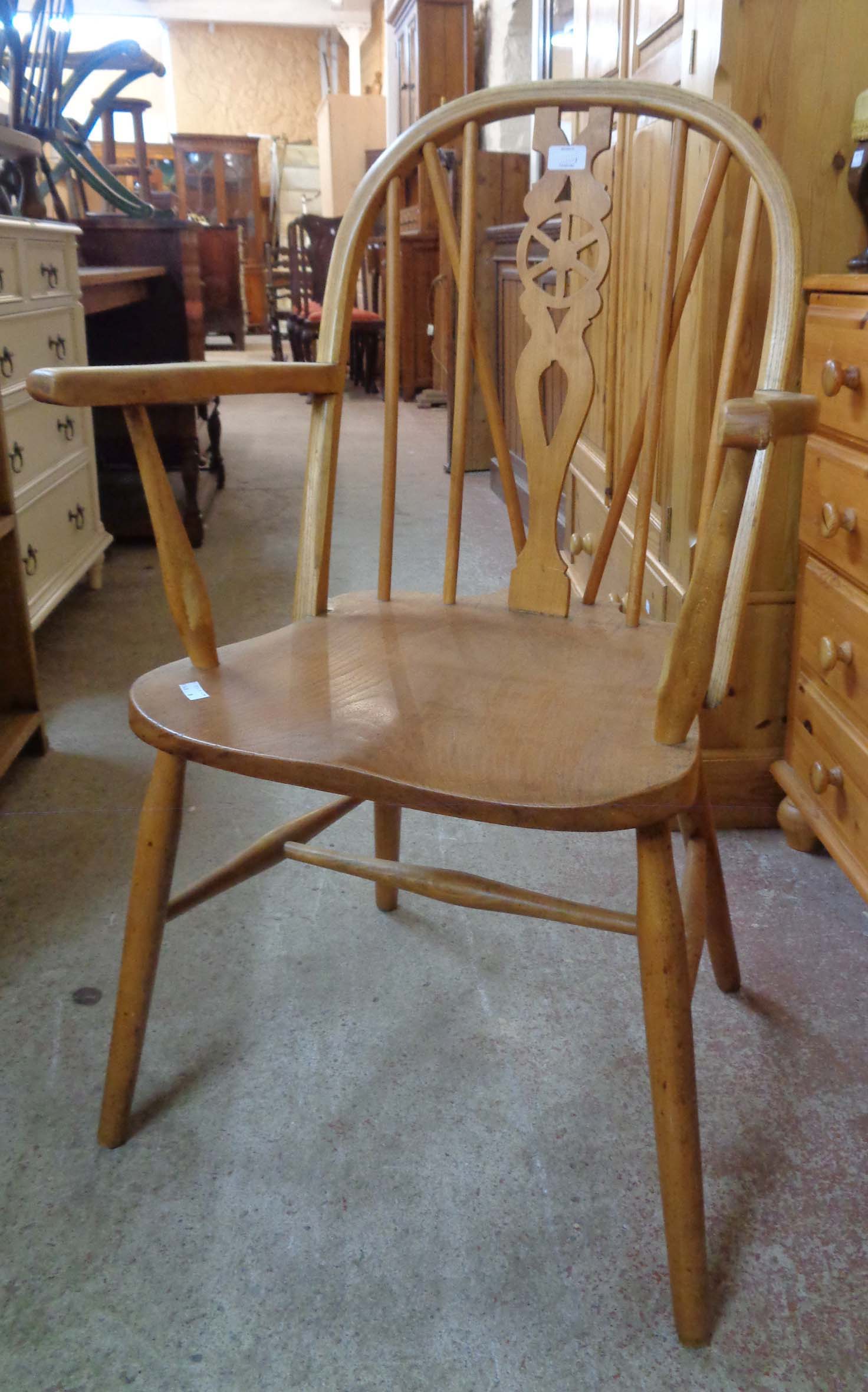A pair of 20th Century wheel back elbow chairs with solid elm seat panels, set on simple turned