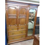 A 5' 6" late Victorian mahogany wardrobe with dentil cornice, three linen slides enclosed by a