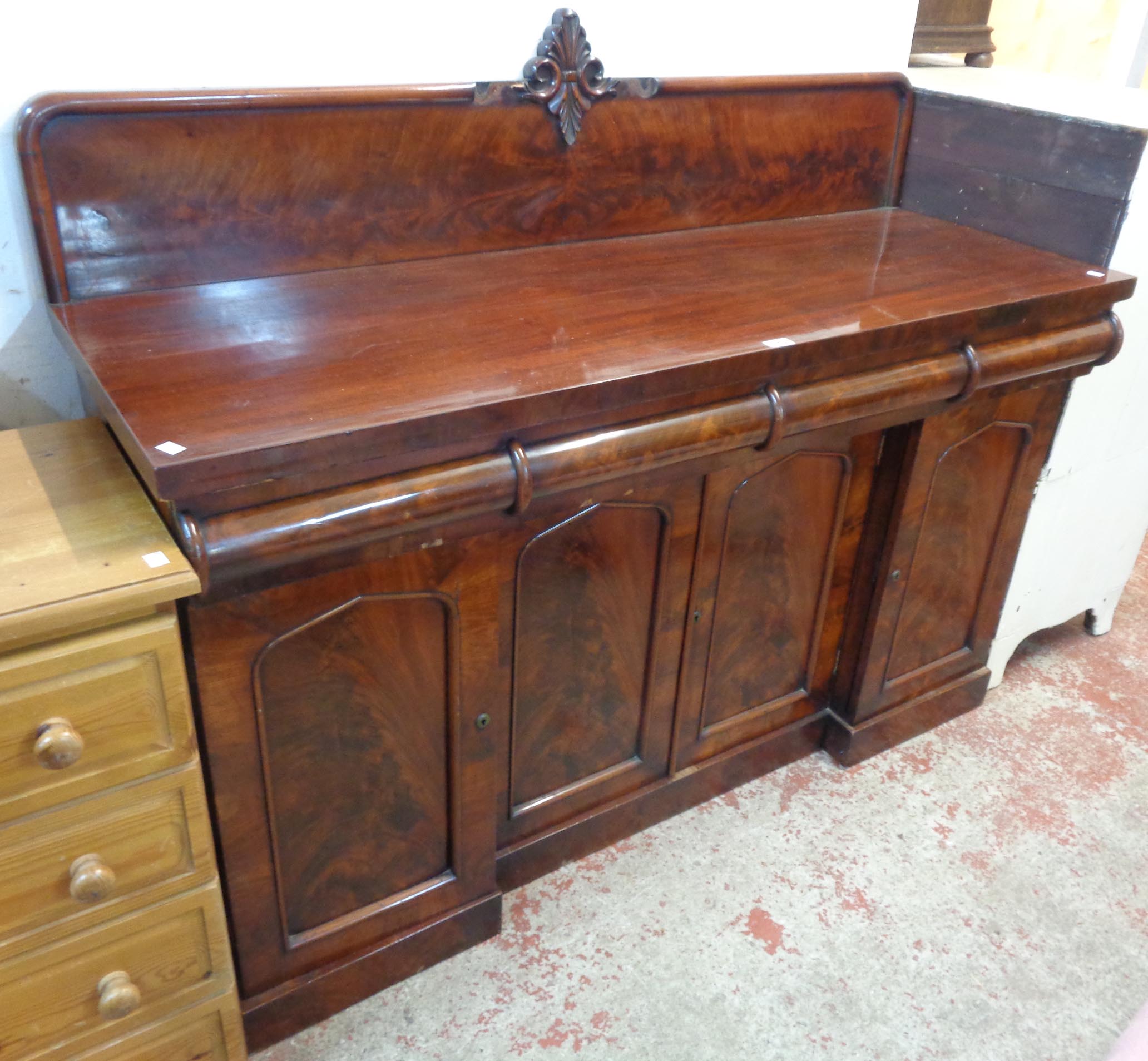 A 5' Victorian flame mahogany sideboard with low raised back, three blind cushion frieze drawers,