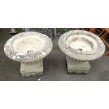 A pair of cast stone urns set on plinth bases