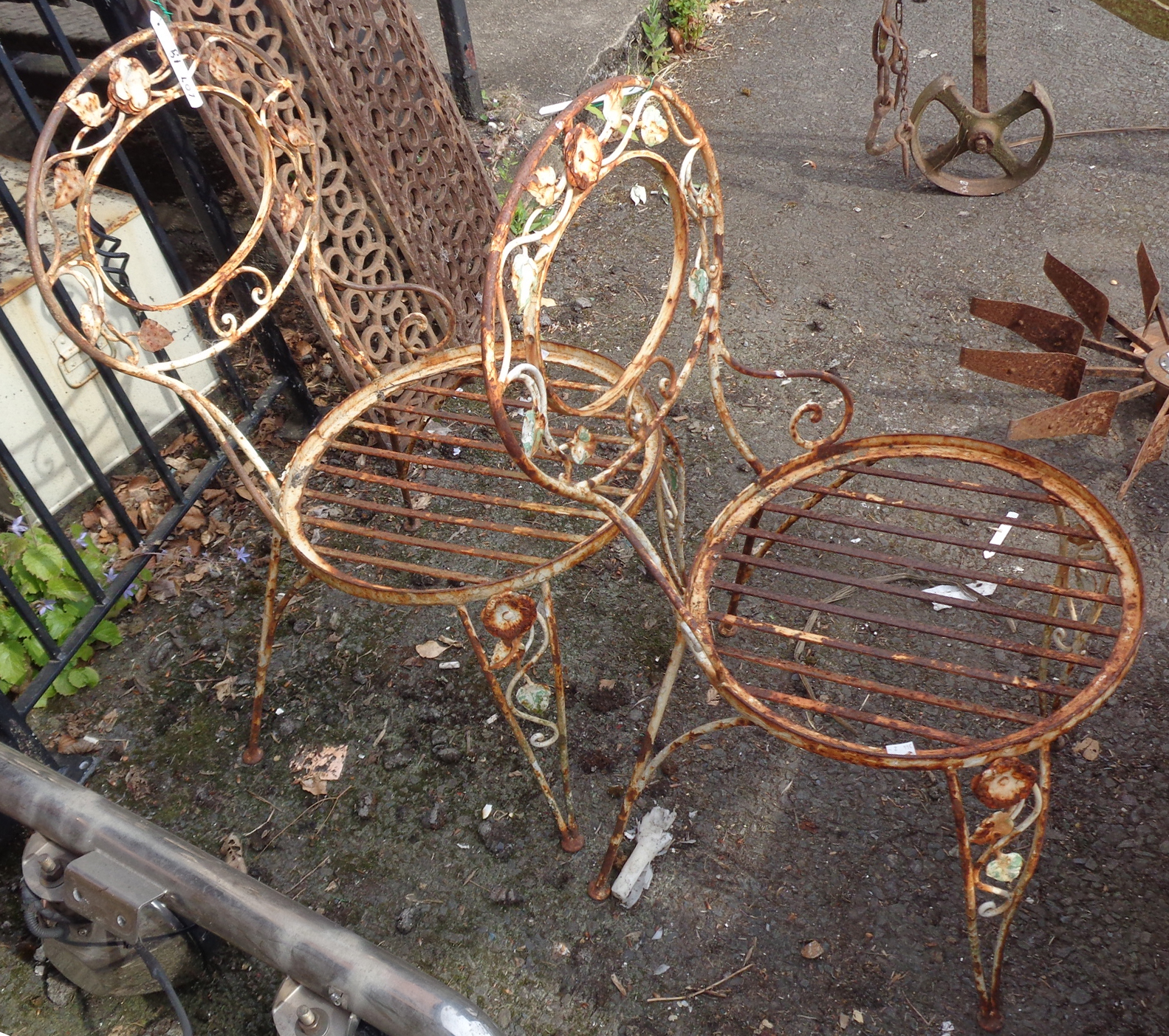 Two vintage metal spoon back garden chairs with floral decoration