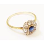 An unmarked high carat yellow metal flower head ring, set with central sapphire within an eight