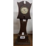 A 13 1/2" early 20th Century stained oak miniature longcase clock with simple timepiece movement and