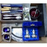 A box containing a quantity of silver plated items including a pair of salts with blue glass liners,