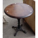 A 23 1/4" diameter polished wood topped tavern table with painted ornate cast iron base