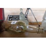 An old ship in a bottle with fishing boat and steam tug before a fishing village - sold with a