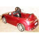 An Alfa Romeo pedal car in burgundy finish