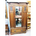 A 3' 9" Art Nouveau walnut single wardrobe with bracketed cornice, flanking decorative panels and