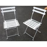 A pair of painted metal folding garden chairs