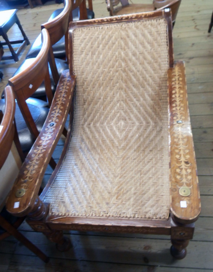 An Eastern ornate inlaid hardwood framed polo chair with woven cane panel and all-over trailing