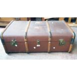 A vintage bentwood and metal bound travelling trunk with canvas weather coating and leather handles