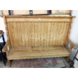 A 6' 10" antique waxed pine settle with shaped top and sides, planked back and solid sectional