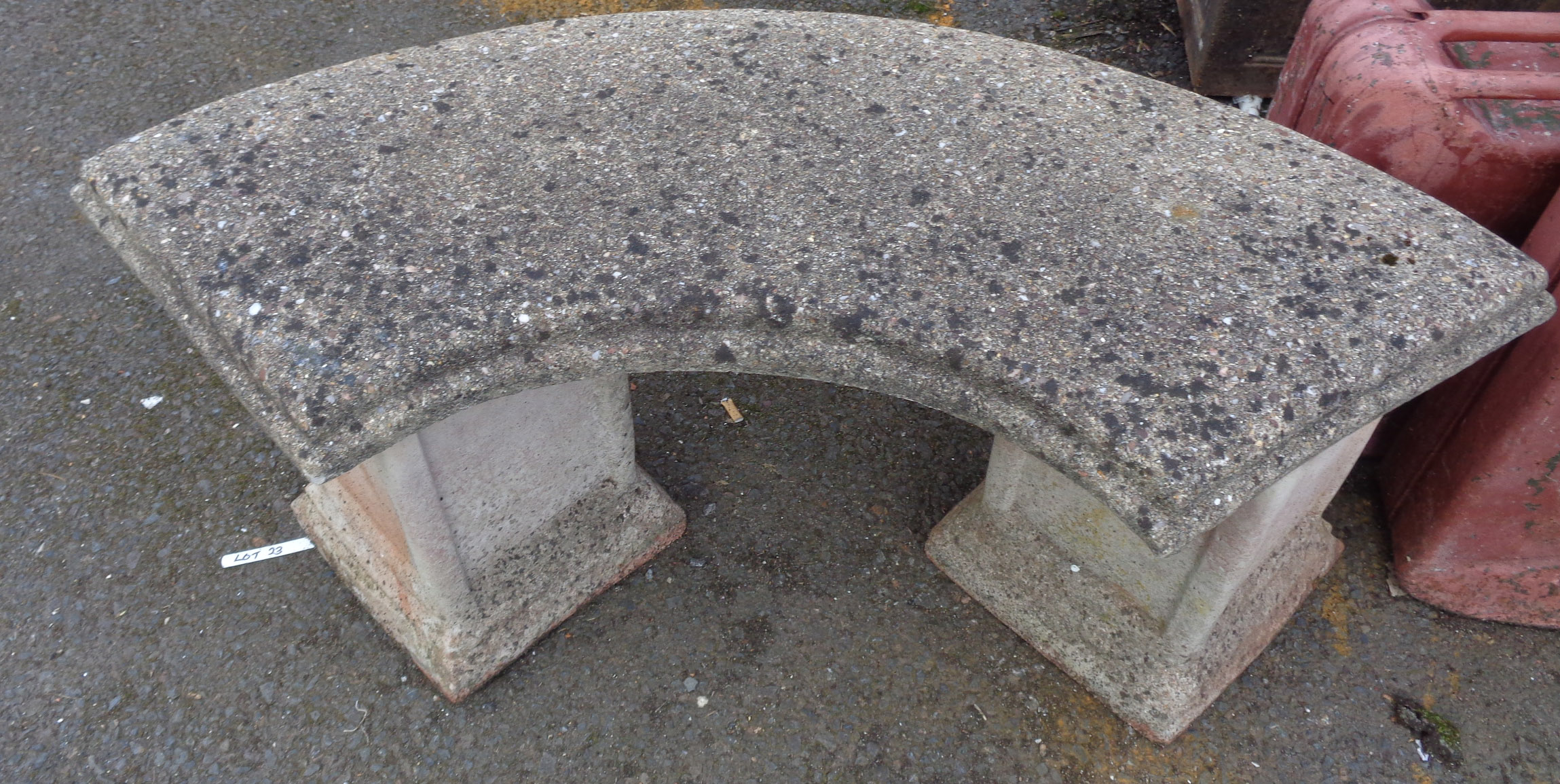 A concrete garden bench with curved seat