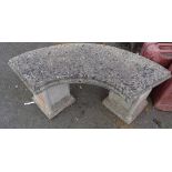 A concrete garden bench with curved seat