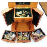 A polished wood jewellery chest containing a quantity of good quality costume jewellery