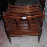 An antique style stained hardwood Canterbury with pierced handle, turned finials and drawer to base,