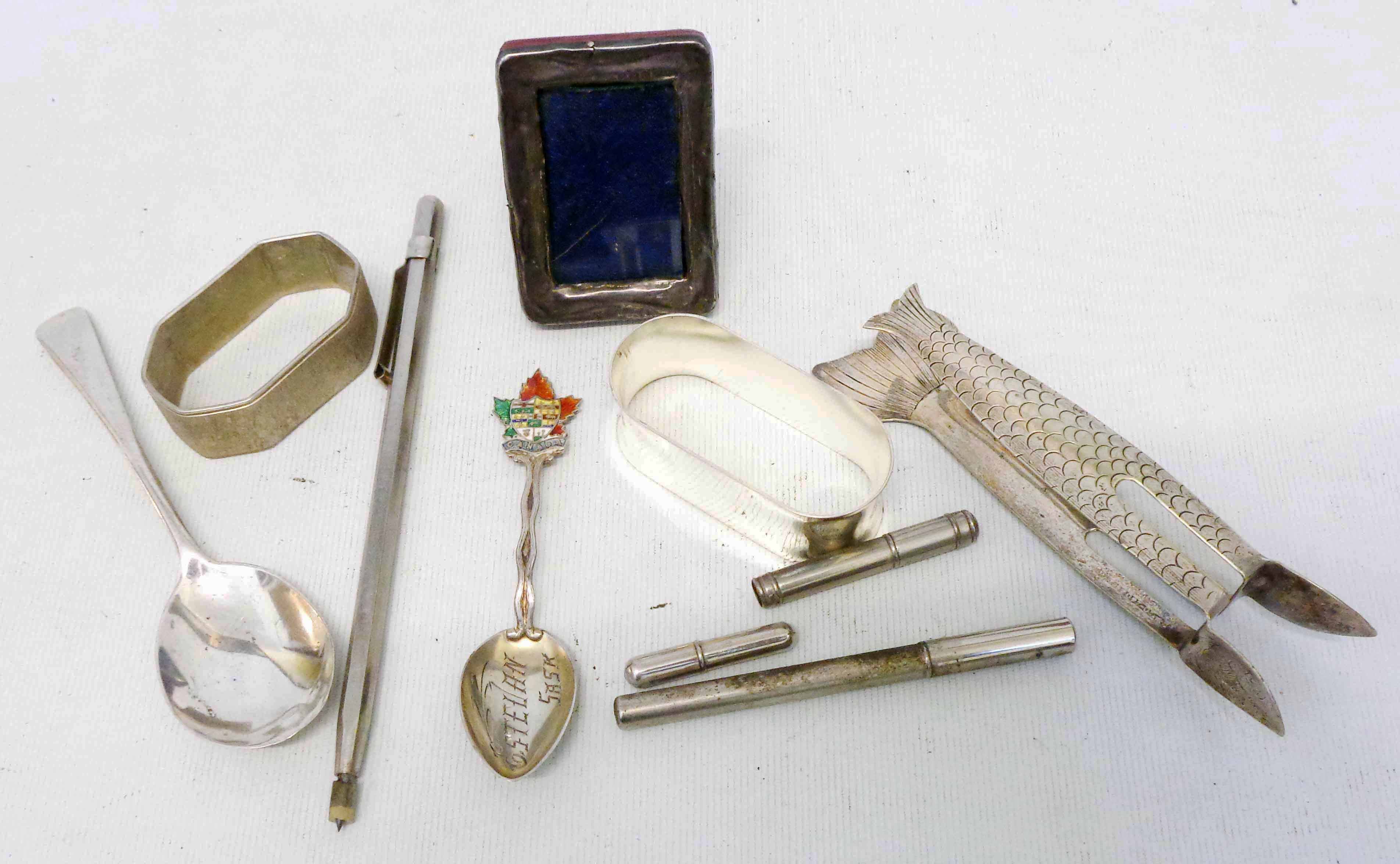 A bag containing silver and white metal items including fish tail pattern tongs, etc.