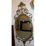 An ornate reproduction gilt framed oval wall mirror