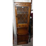 A 21 1/4" stained oak two part cabinet with leaded glazed door and two short drawers to top over a