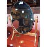 A 20th Century stained wood framed dressing table mirror with oval plate and slender swept supports