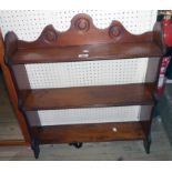 A 25 1/4" Edwardian oak wall mounted three shelf unit with pegged shaped standard ends