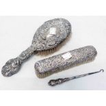 A silver backed hair brush, another and a button hook