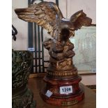 A metal eagle with painted bronze finish, set on a socle base